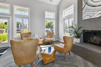 a living room with chairs and a fireplace